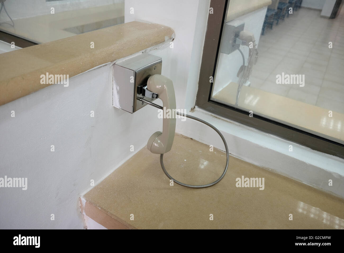 Phone handset used by inmate and visitor to talk. behind glass during visiting hours in a prison Israel Stock Photo