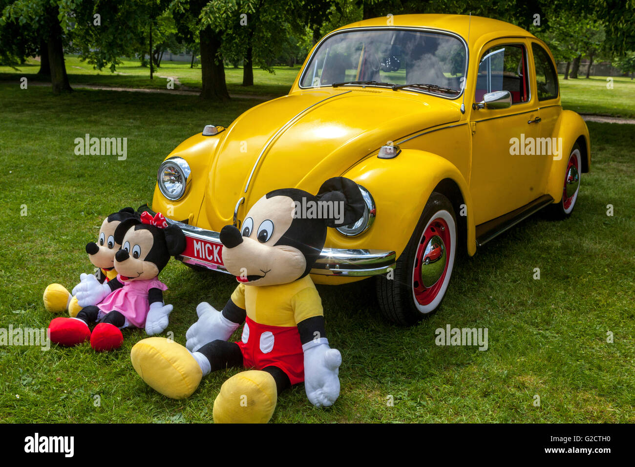 Yellow VW car beetle and Mickey mouse toys family, Car toys Stock Photo