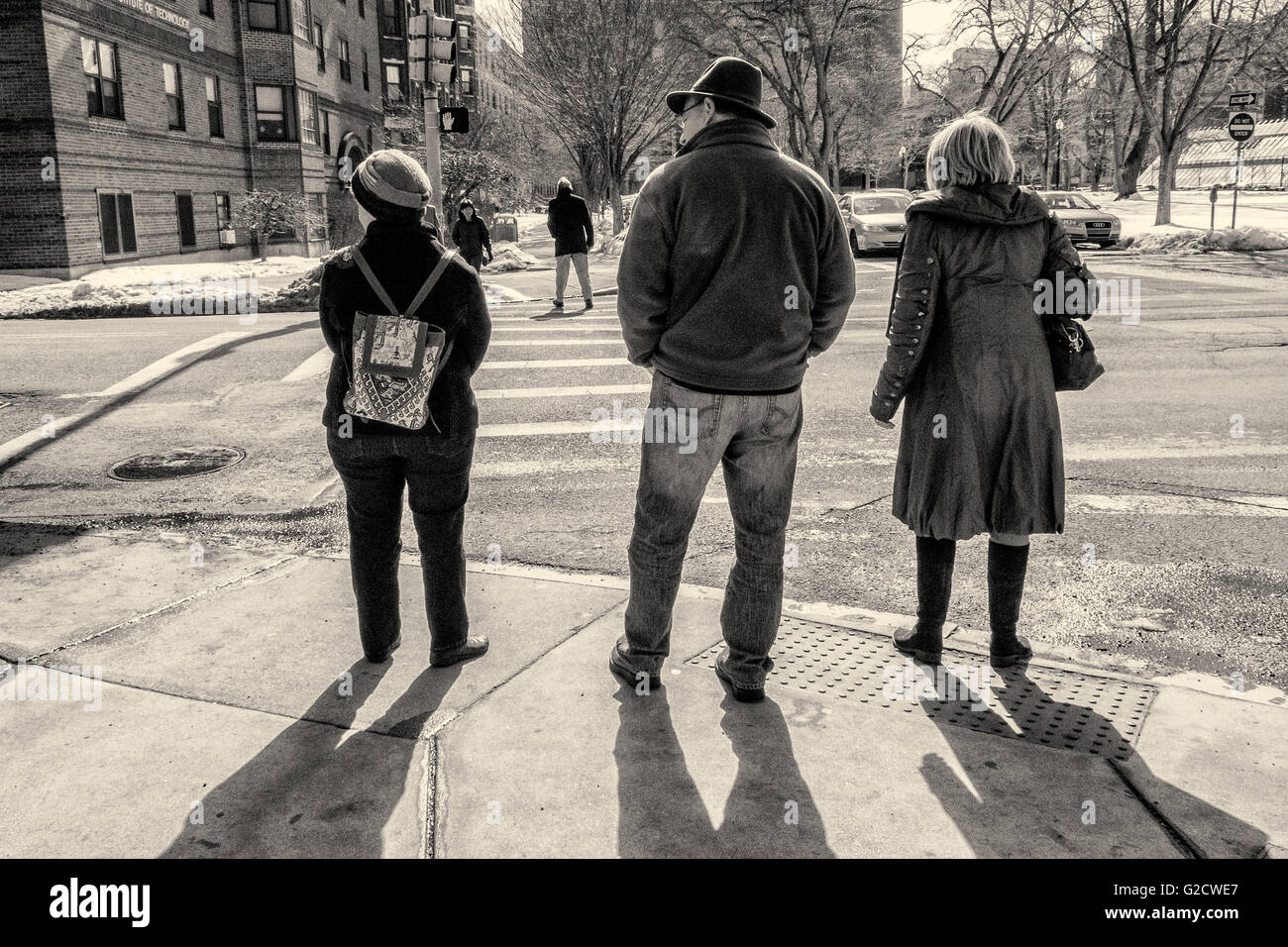 Three people waiting to cross the street in Boston, MA Stock Photo