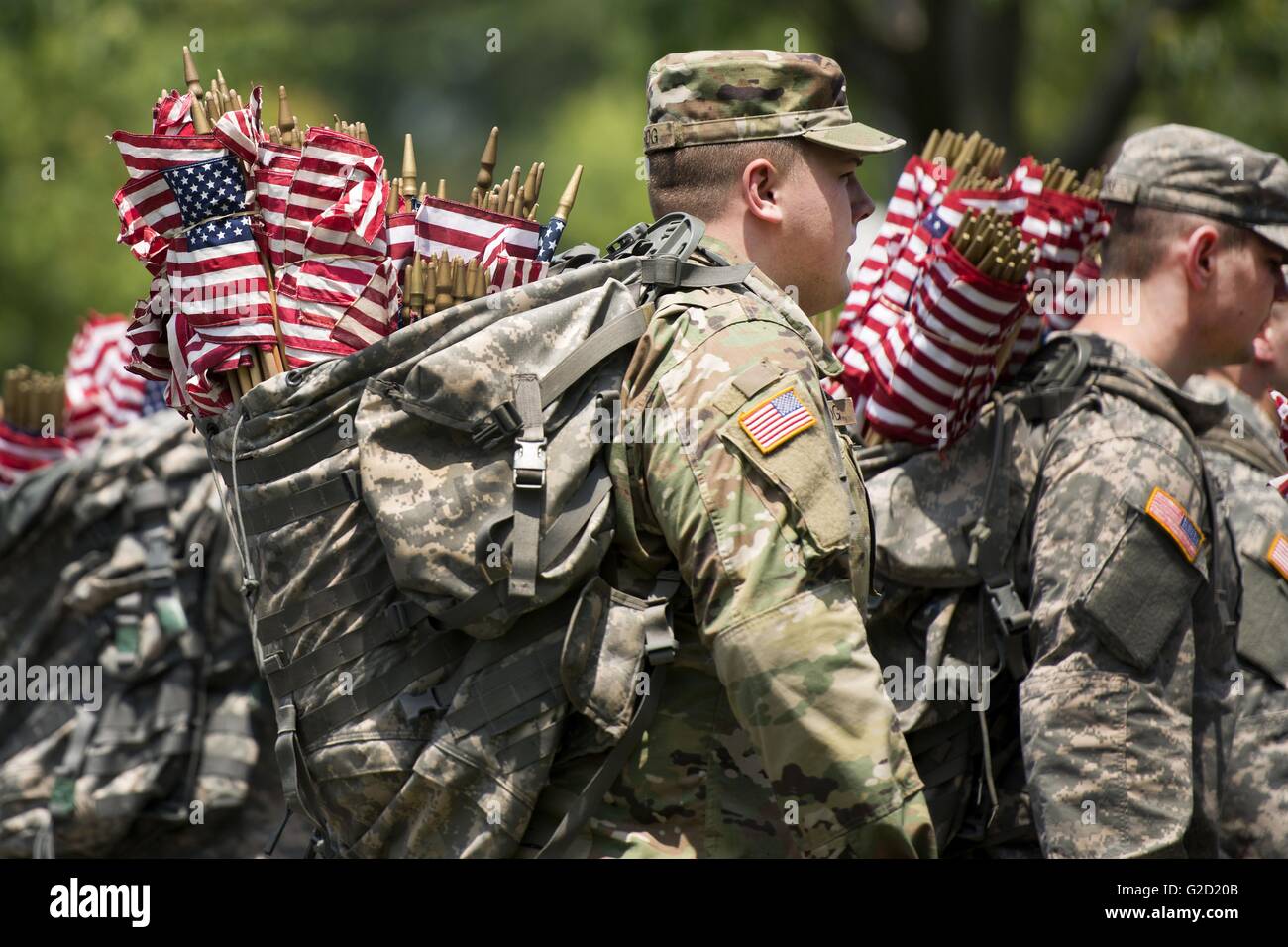 Arlington National Cemetery, Virginia, USA. 27th May, 2016. U.S soldiers with The Old Guard carry hundreds of American flags as they prepare to place them in front of gravesites in Arlington National Cemetery in honor of Memorial Day May 27, 2016 in Arlington, Virginia This tradition, known as 'Flags In,' has been conducted annually since The Old Guard was designated as the Army's official ceremonial unit in 1948. Credit:  Planetpix/Alamy Live News Stock Photo