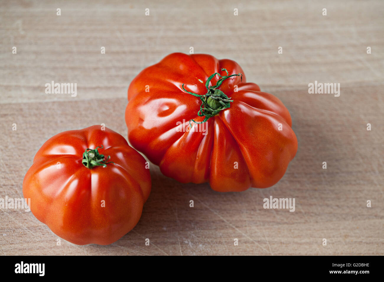Big and ripe red tomatoes on wooden board Stock Photo