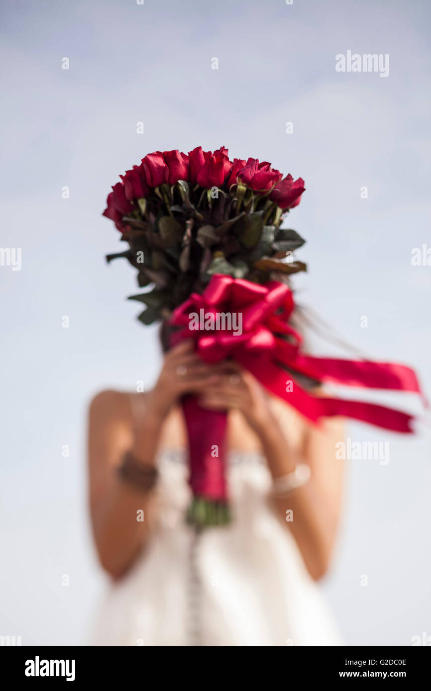 Young Woman Holding Bouquet of Red Roses in Front of Face Stock Photo ...