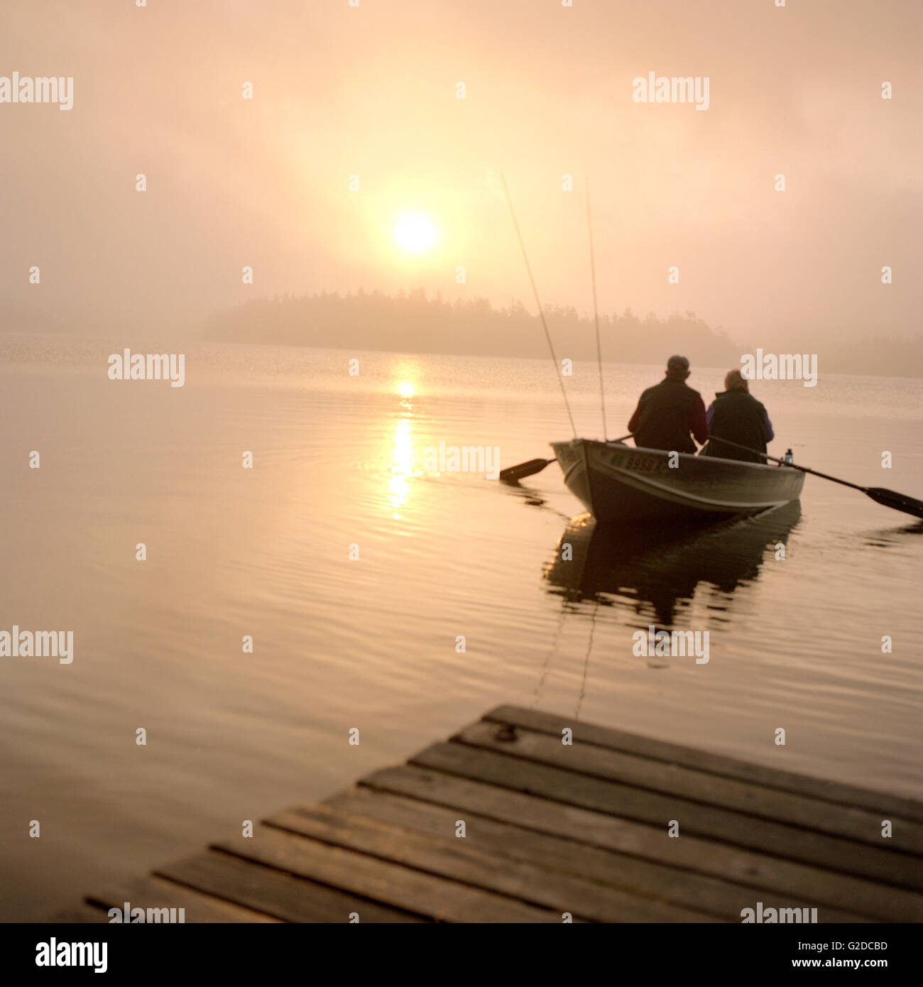 Couple in Row Boat at Sunrise Stock Photo