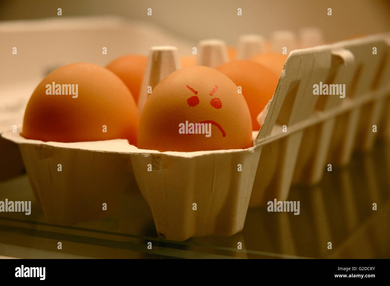 Carton of Eggs with one Egg Displaying an Angry Face Stock Photo