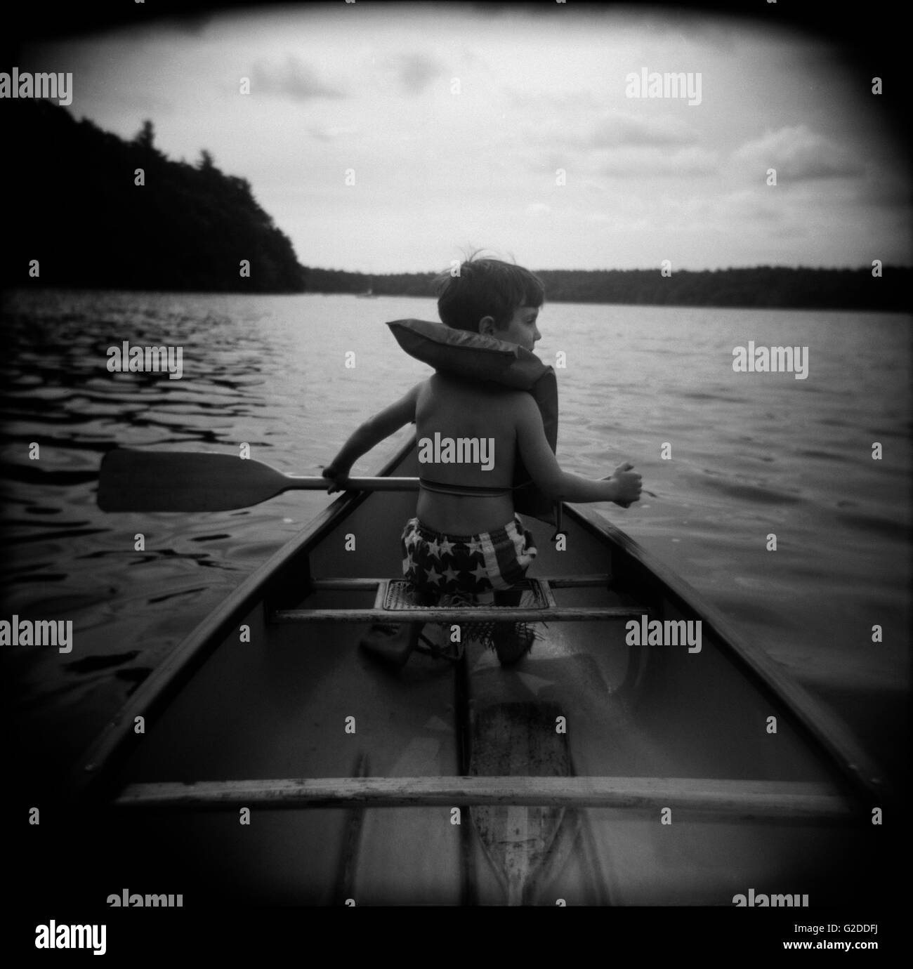 Boy in Canoe, Rear View Stock Photo - Alamy