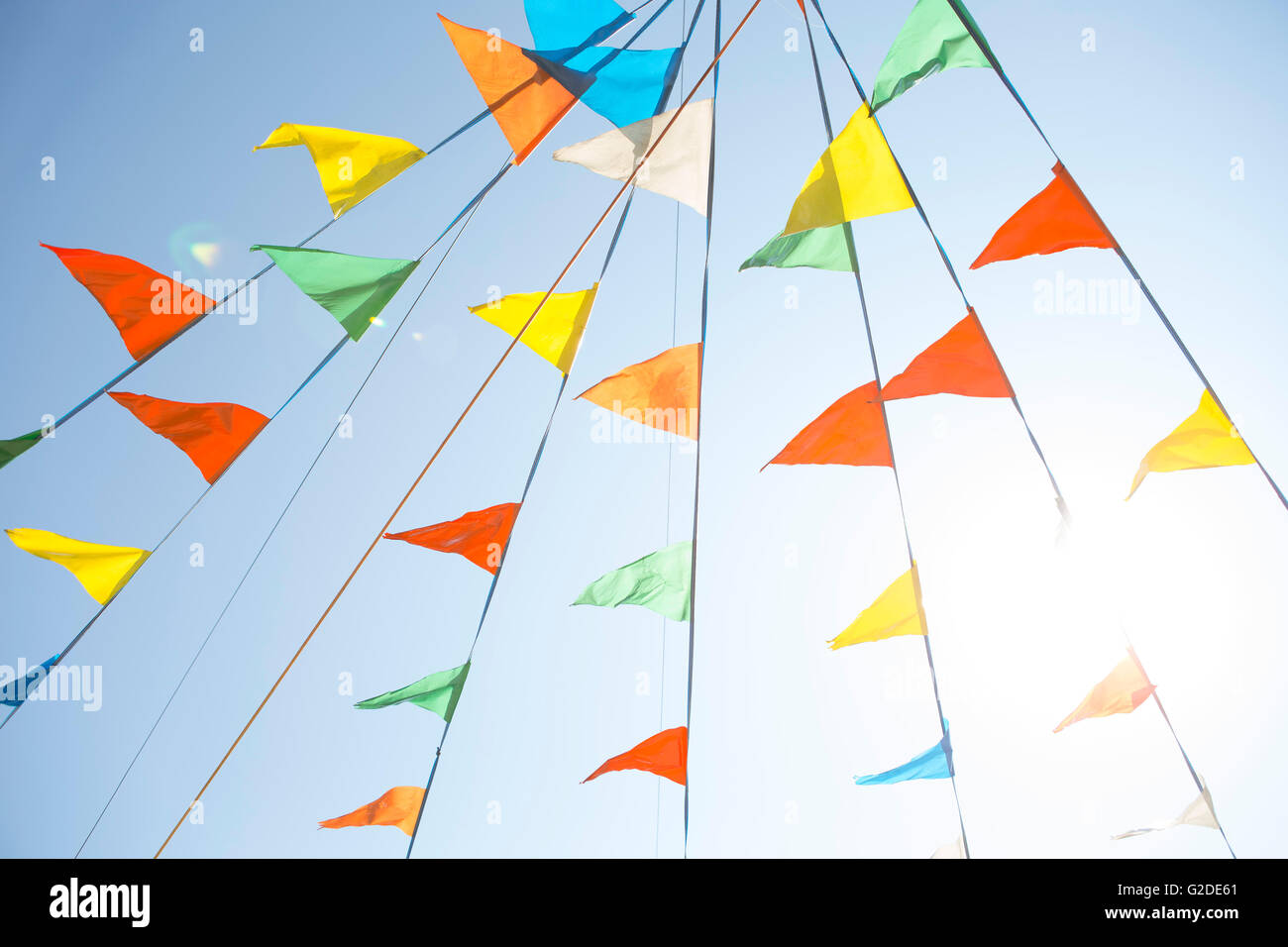 Colorful Pennant Flags Against Blue Sky, Low Angle View Stock Photo