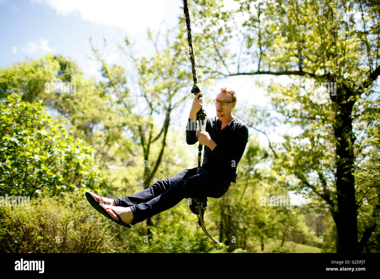 Man Swinging on Rope Stock Photo