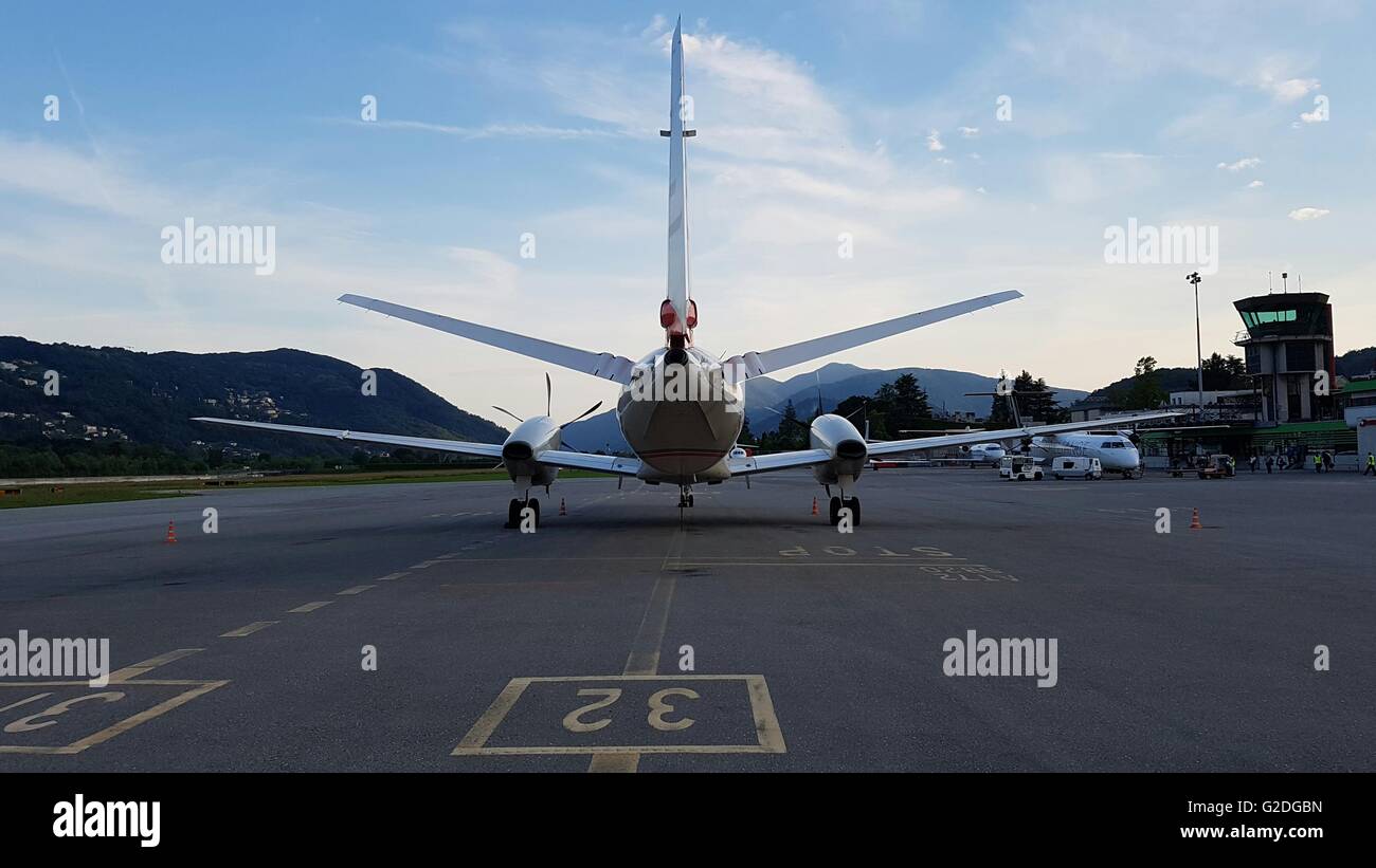 Airplane on tarmac facing sunset and control tower Stock Photo - Alamy