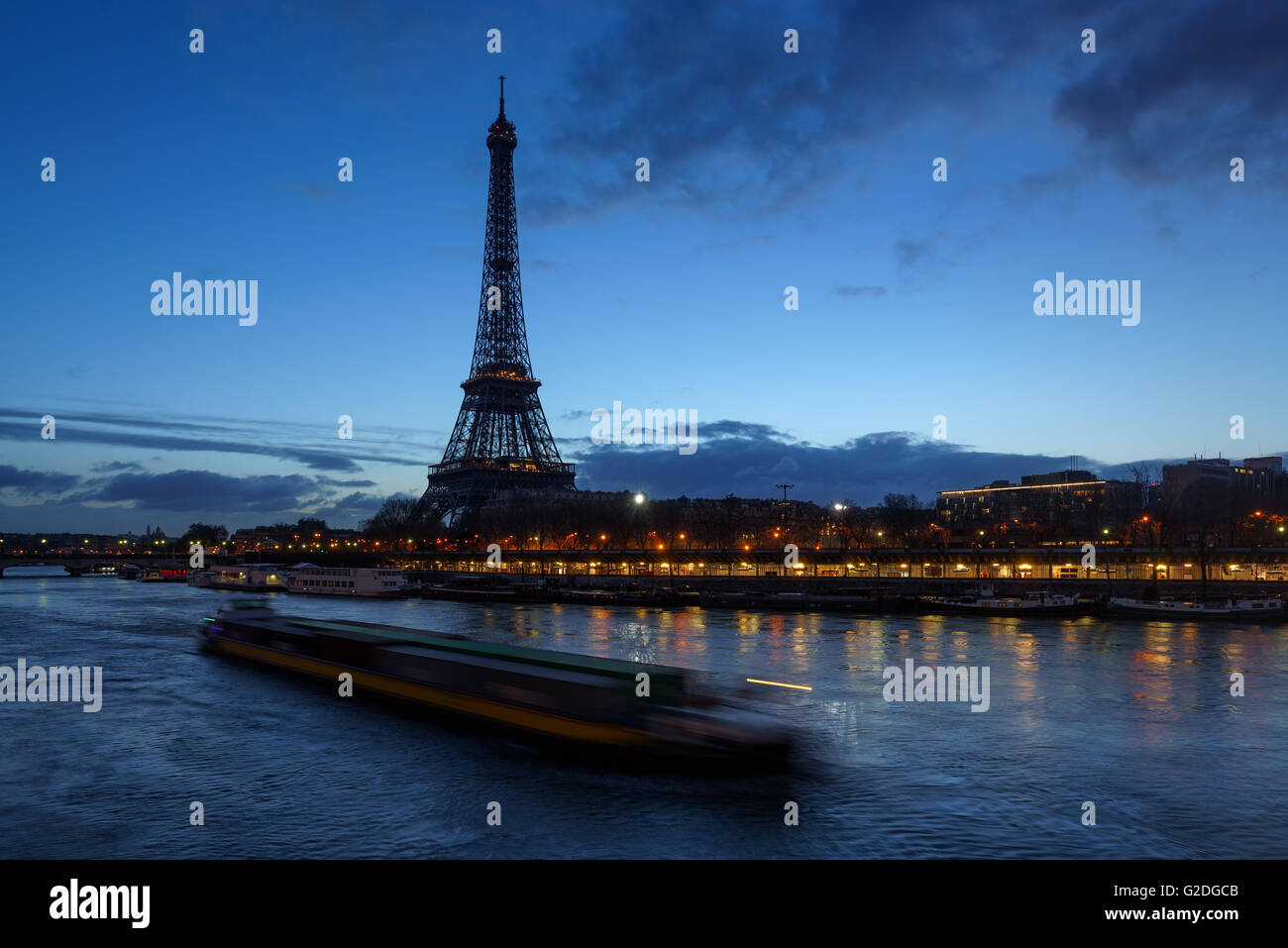 Eiffel Tower and Seine River at dawn with a passing barge. Port de Suffren, Paris, 75015, France Stock Photo