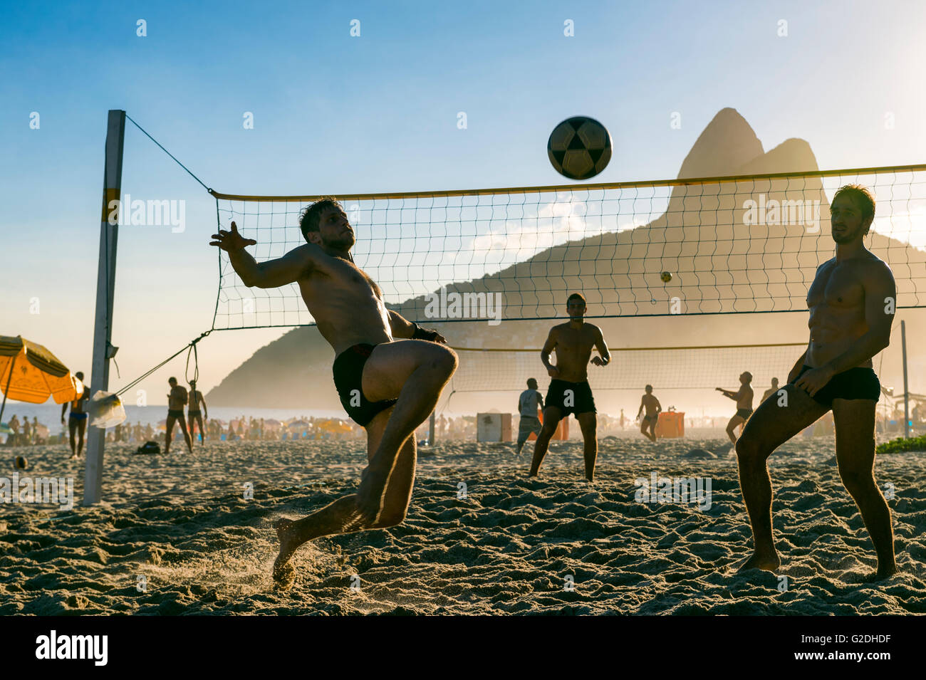 RIO DE JANEIRO - MARCH 27, 2016: Brazilians play futevôlei (footvolley, a sport combining football/soccer and volleyball). Stock Photo