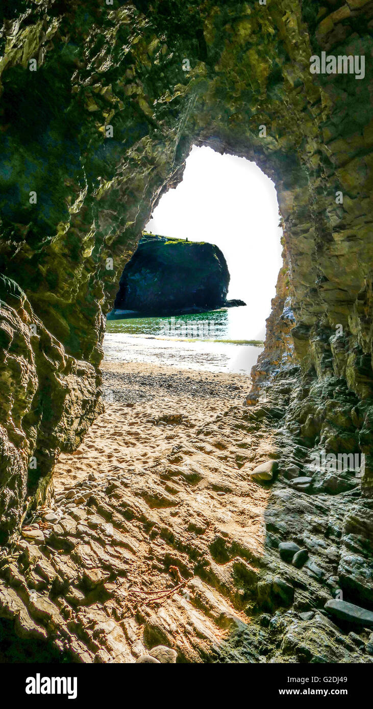 View looking out onto the beach from the inside of a cave though to have been used by 18th century smugglers Llangrannog,  Wales Stock Photo