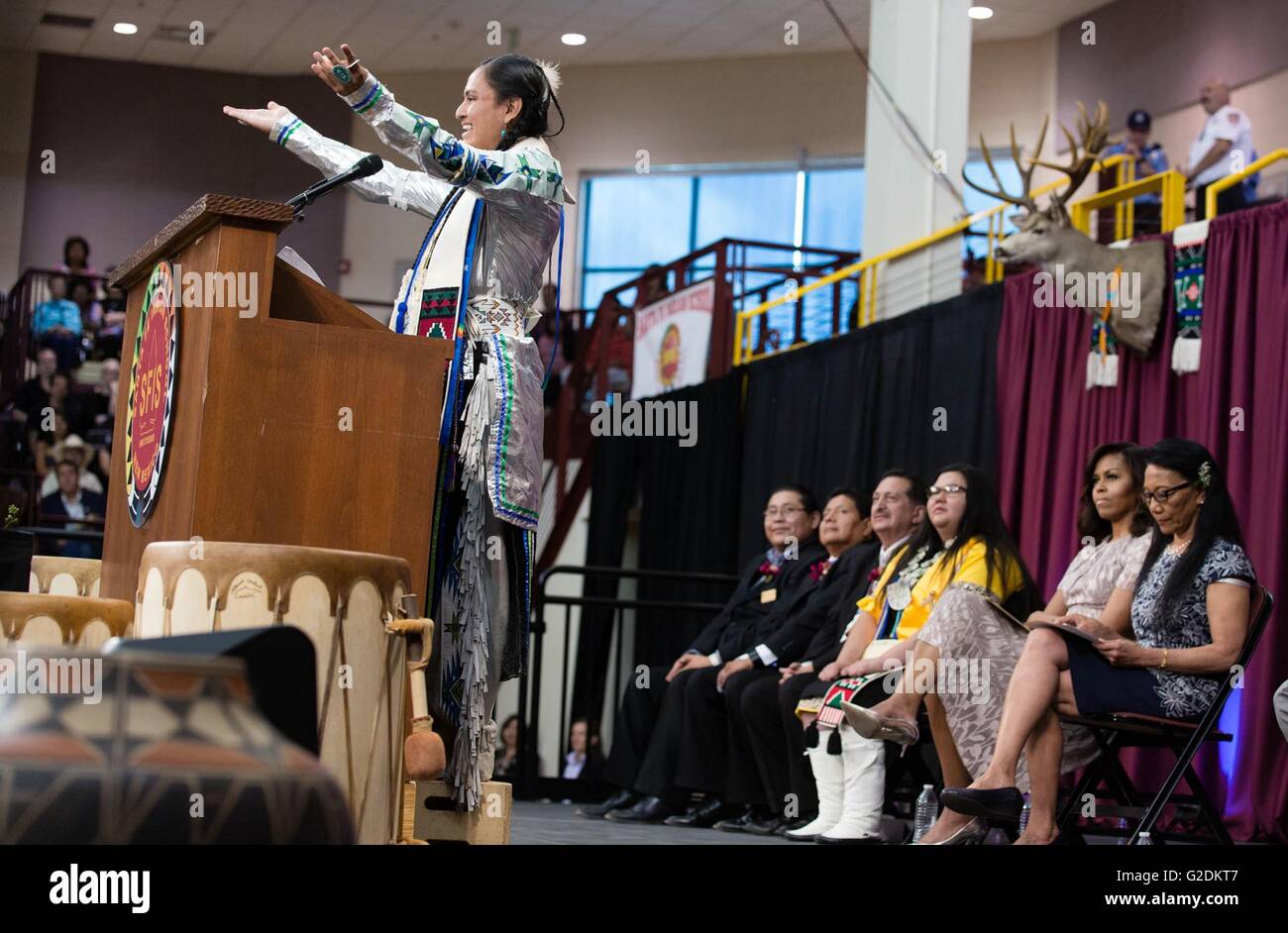 Emanuel Vigil delivers the Valedictorian speech as U.S First Lady Michelle Obama looks on during the Santa Fe Indian School high school commencement ceremony May 26, 2016 in Santa Fe, New Mexico. Stock Photo