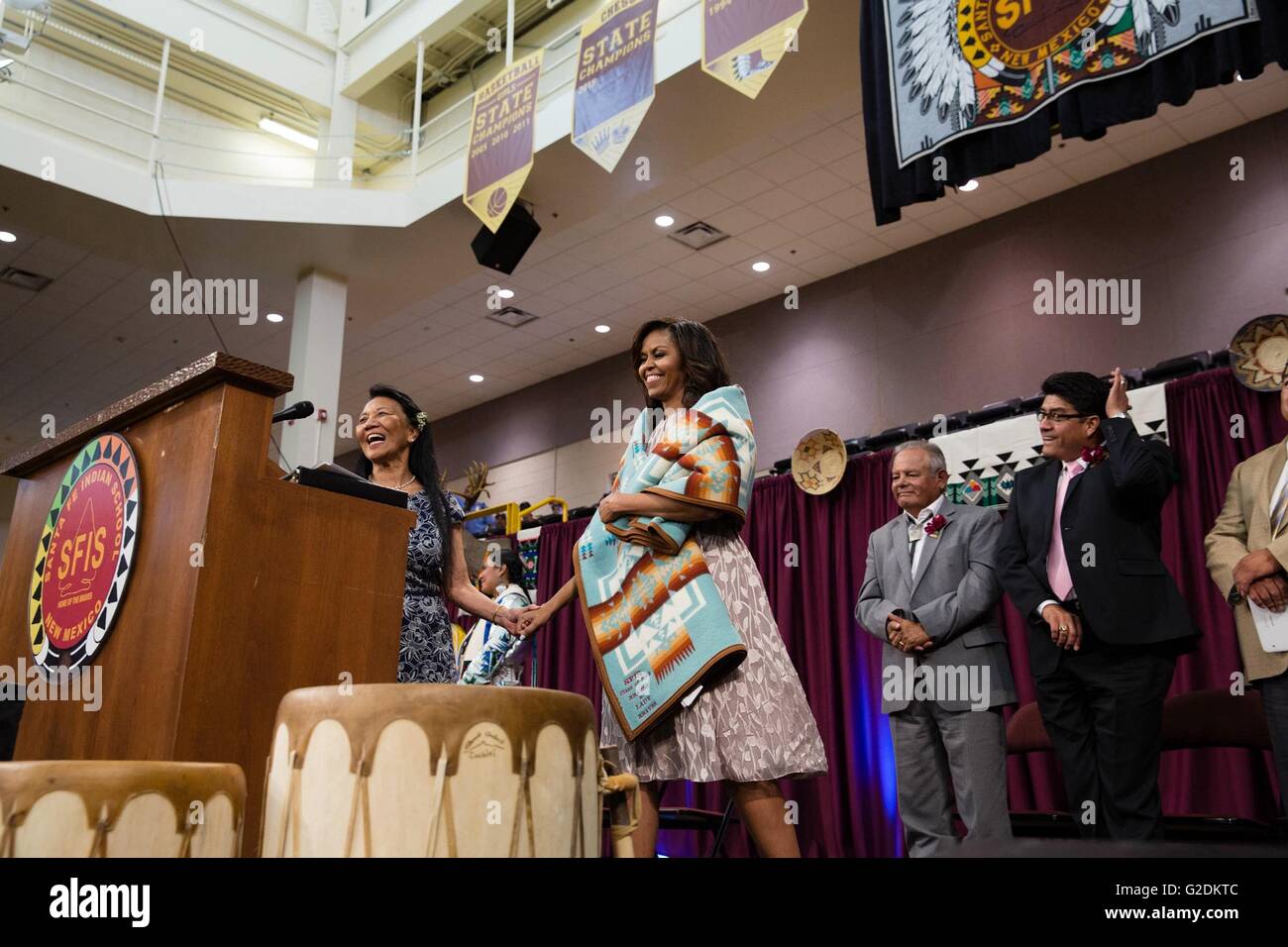 U.S First Lady Michelle Obama shows off a traditional blanket during the Santa Fe Indian School high school commencement ceremony May 26, 2016 in Santa Fe, New Mexico. Stock Photo