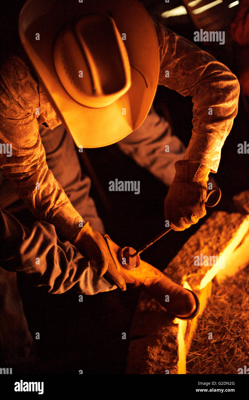 Cowboy Boots Being Branded with Branding Iron Stock Photo