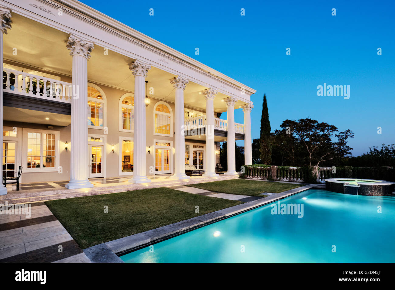 Mansion with Columns and Swimming Pool at Dusk Stock Photo