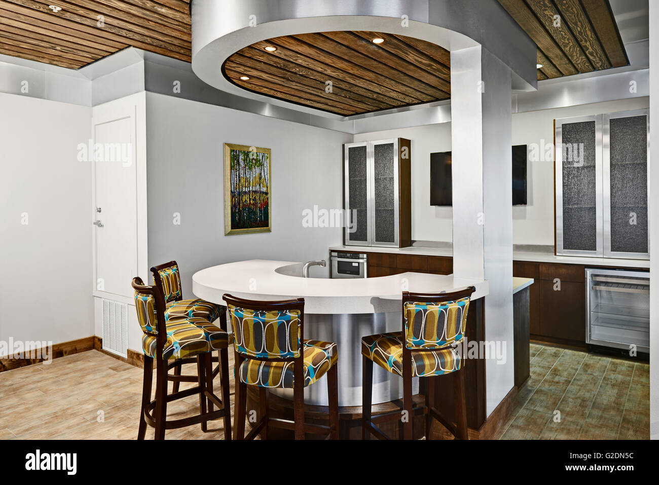 Modern Kitchen With Circular Counter and Colorful Counter Stools Stock