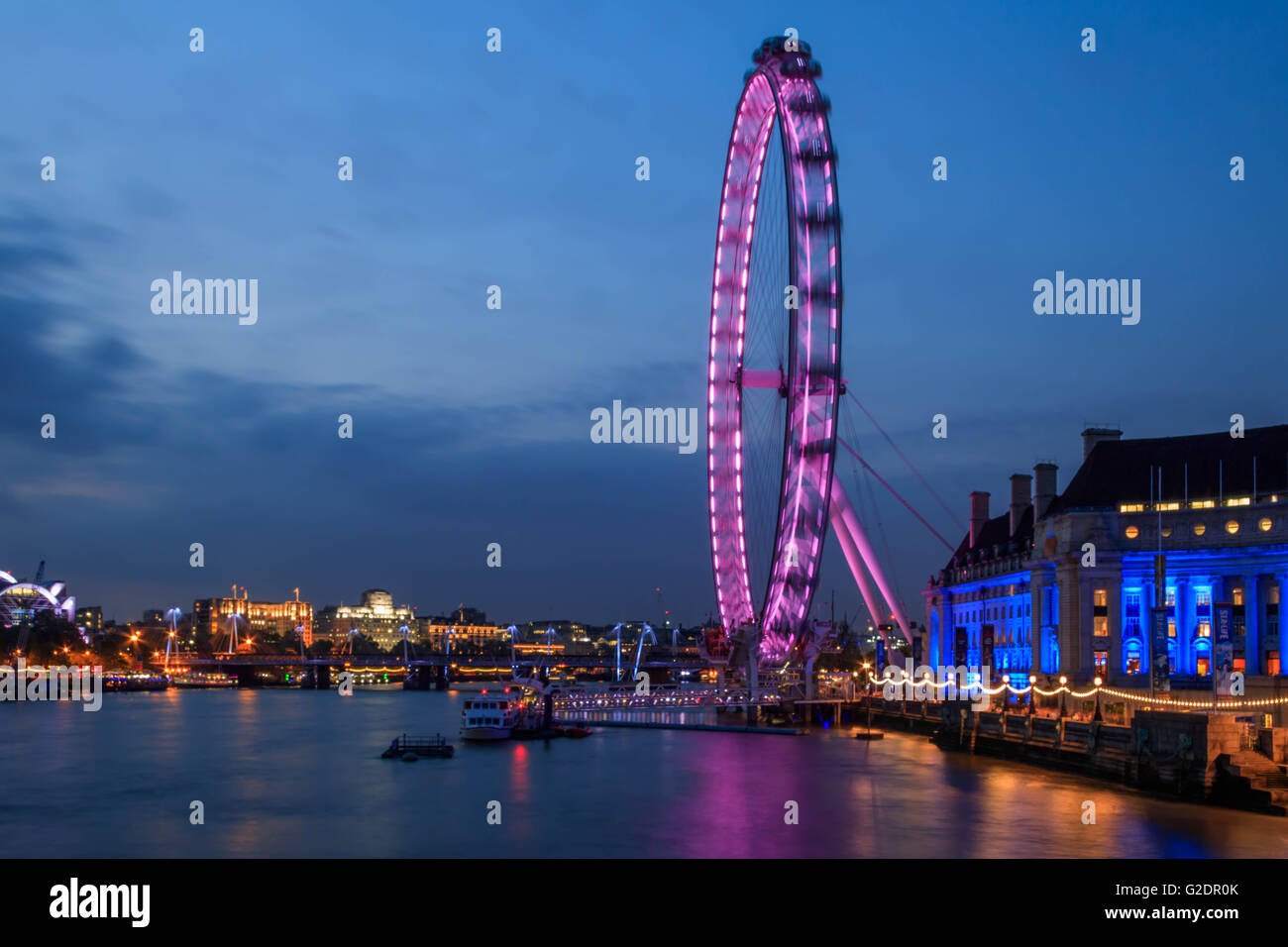 The London eye at night taken from the Westminster's bridge. The sky clear and blue with the London sky line looking east Stock Photo