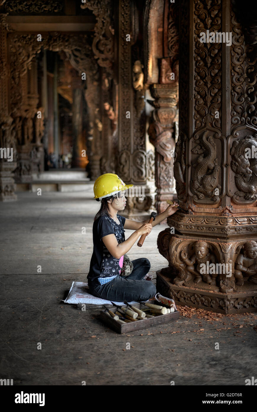 Craftswoman Thailand. Young female builder sculpting and carving wood at the Sanctuary of truth Buddhist Hindu temple. Pattaya Thailand S. E. Asia Stock Photo