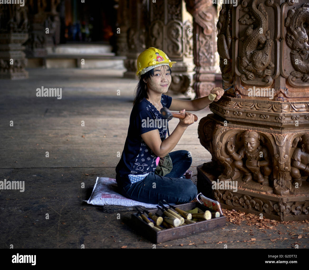 Craftswoman Thailand. Young female builder sculpting and carving wood at the Sanctuary of truth Buddhist Hindu temple. Pattaya Thailand S. E. Asia Stock Photo