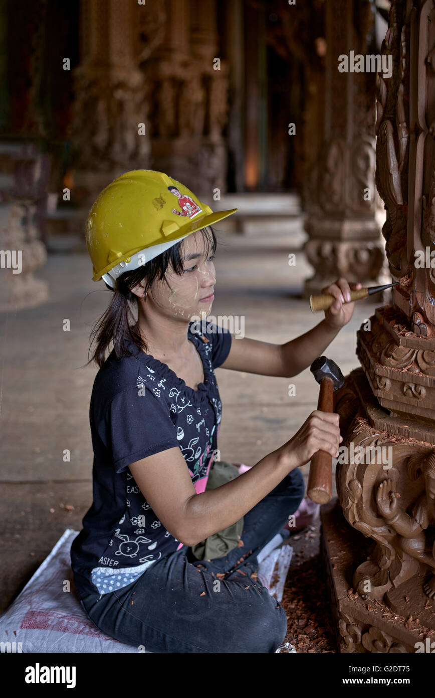 Craftswoman Thailand. Young female builder sculpting and carving wood at the Sanctuary of truth Buddhist Hindu temple. Pattaya Thailand S. E. Asia Stock Photo