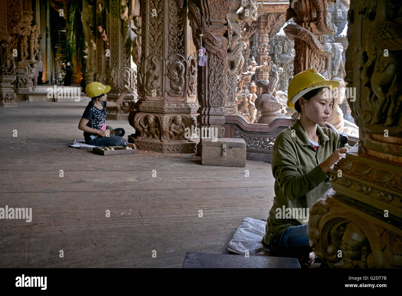 Craftswoman Thailand. Young female builders sculpting and carving wood at the Sanctuary of truth Buddhist Hindu temple. Pattaya Thailand S. E. Asia Stock Photo
