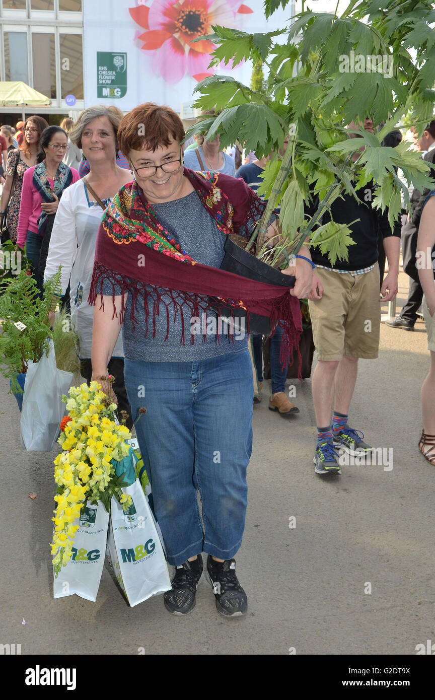 A woman takes home plants on the last day of the 2016 RHS Chelsea Flower Show at the Royal Hospital Chelsea, London. Stock Photo