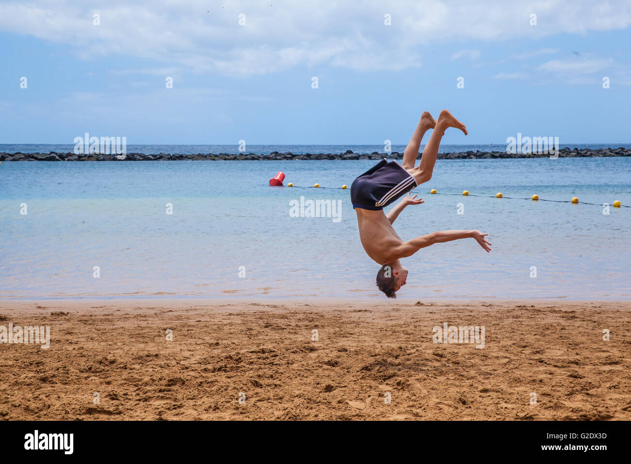 young sportsmen doing martial arts tricking sports on the beach Stock