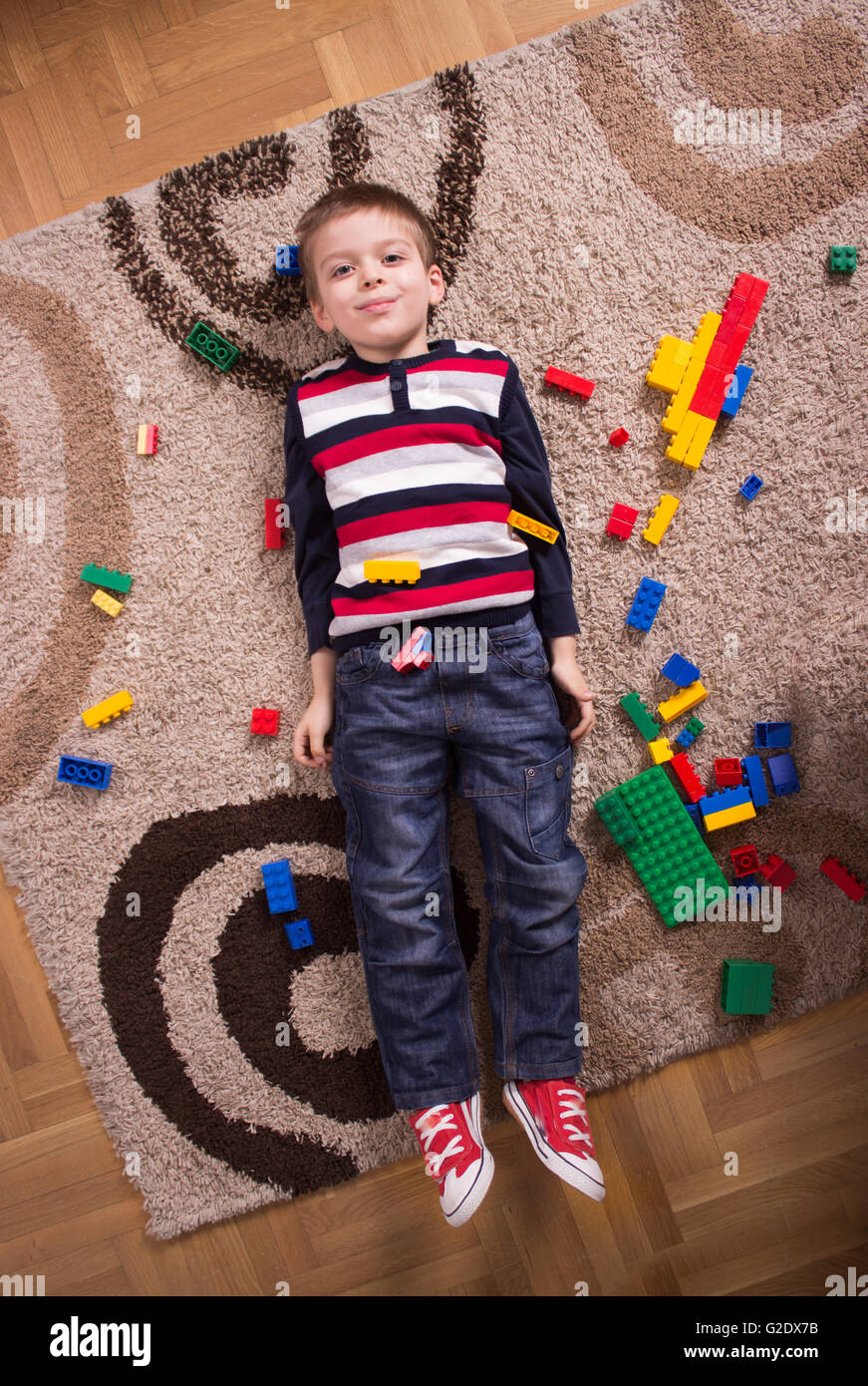 Elevated view, cute kid laying on back. Stock Photo