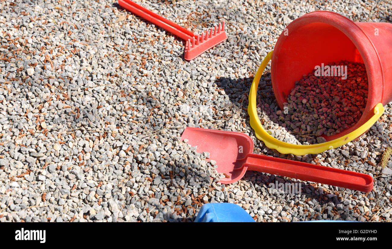 Rake, shovel and bucket child on playground gravel.Horizontal composition. Stock Photo