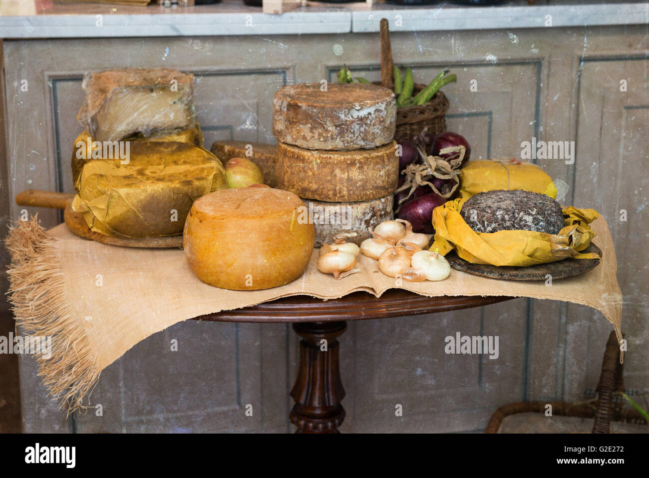 Old style Italian cheese wheels on a rustic display table Stock Photo