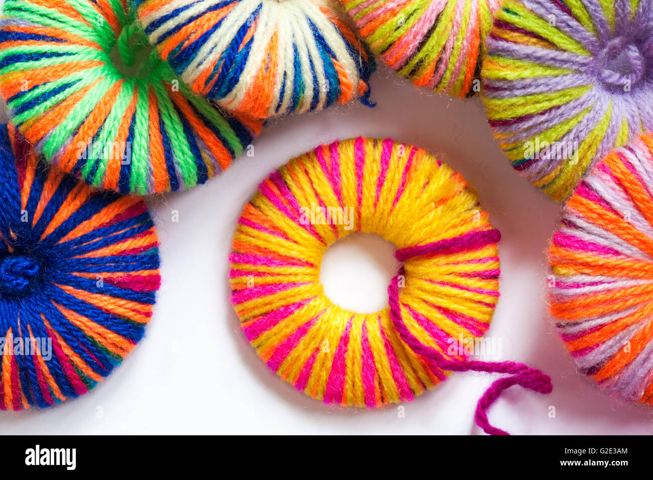 Making multicoloured home made poms poms from different coloured wool