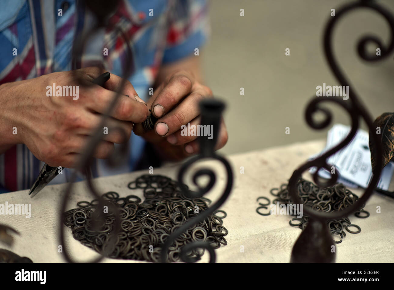 Master blacksmith engaged in assembling of chainmail rings Stock Photo
