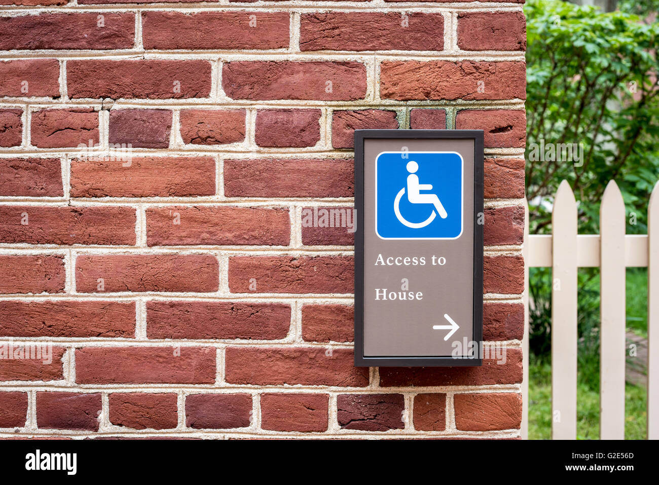Handicap access sign on brick wall Stock Photo