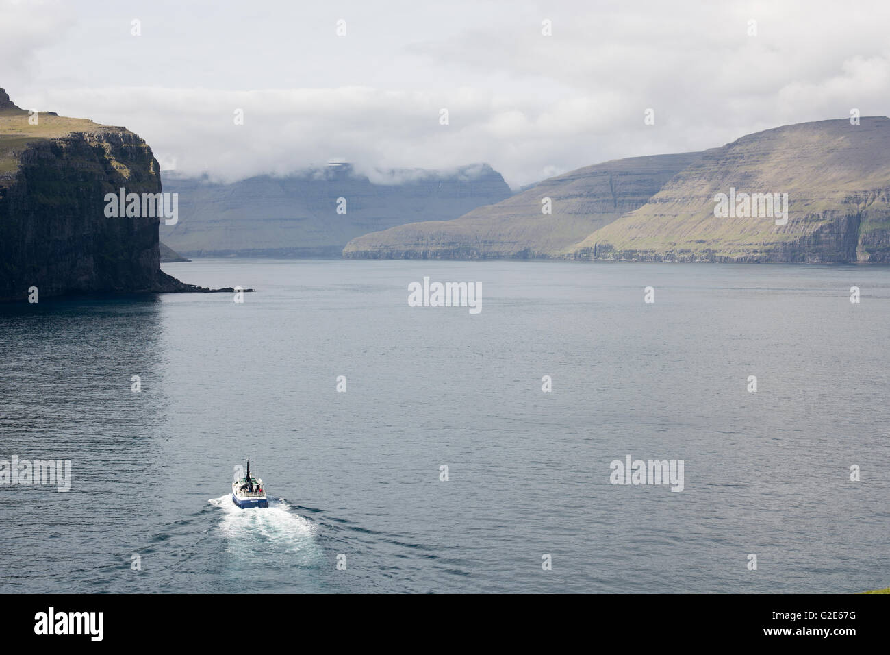 The islands Svinoy and Vidoy on the Faroe Islands with the ferry MS Ritan on the water Stock Photo