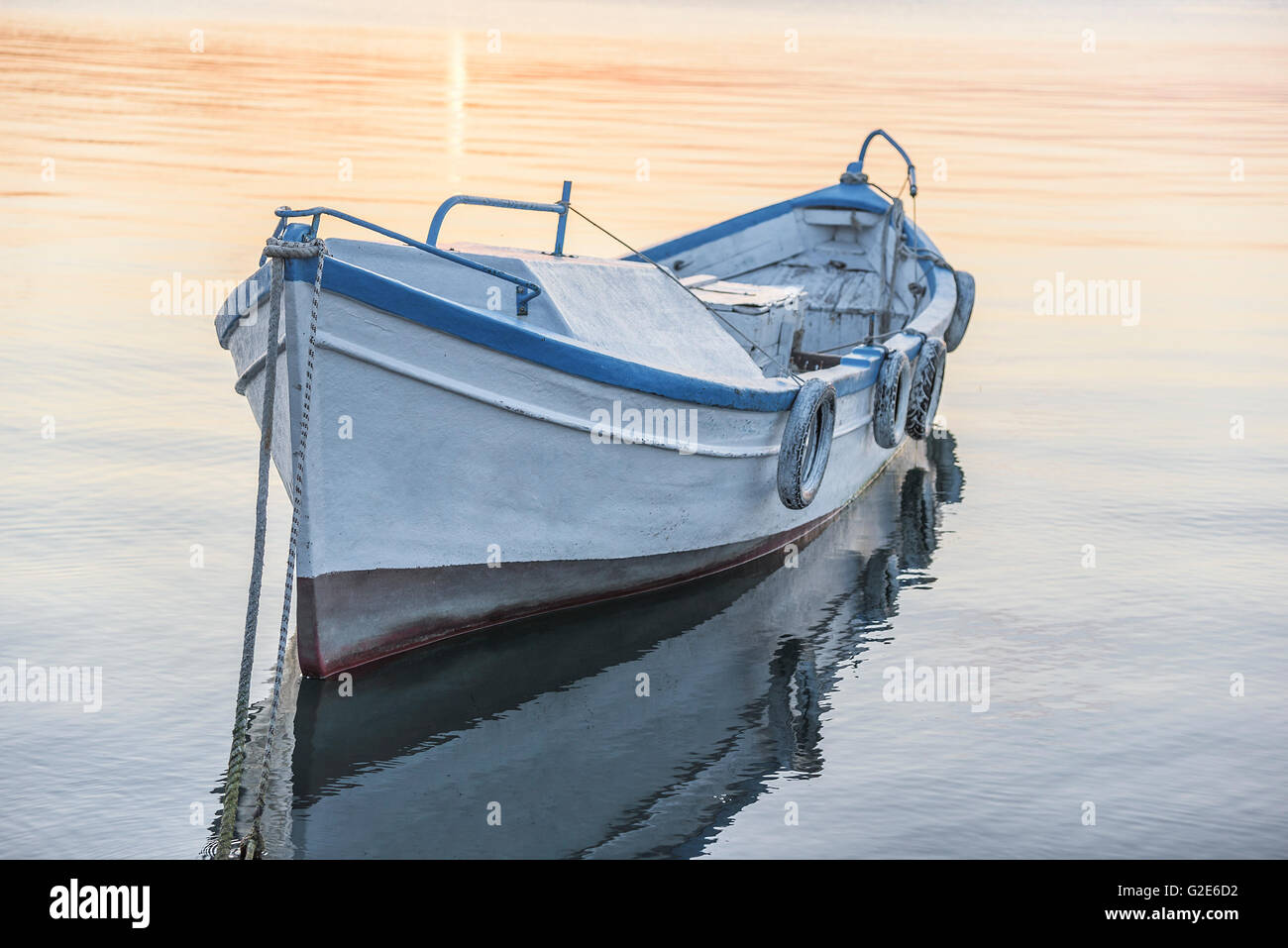 Fishing boat on the sea water at sunset Stock Photo - Alamy