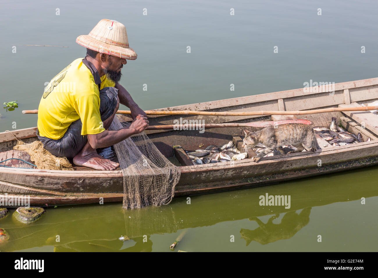 Fisherman on boat near the longest ancient teak wood bridge. U-Bein bridge, Amarapura, Mandalay, Burma Stock Photo