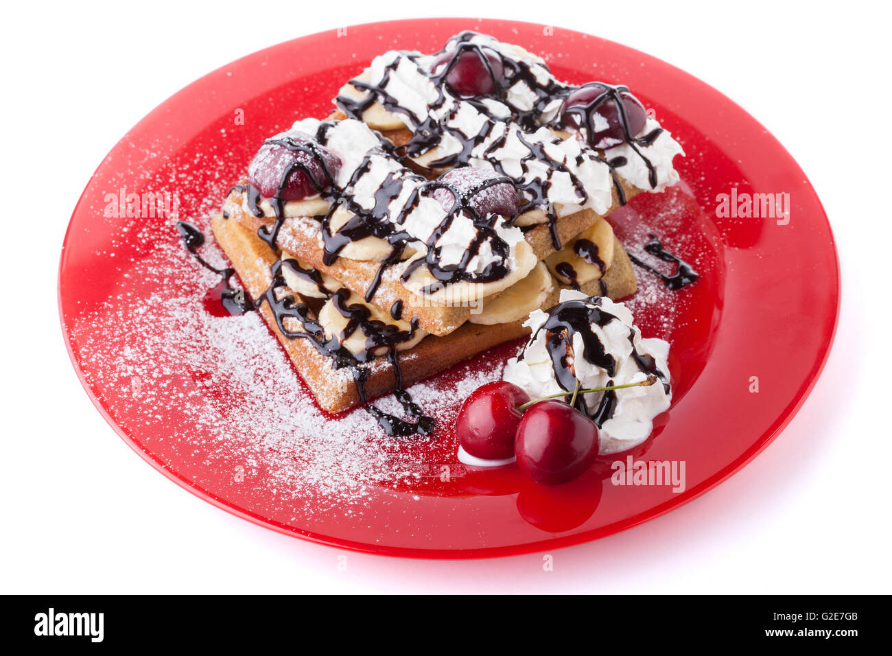 Belgian waffle with chocolate syrup whipped cream and red cherry on red ...