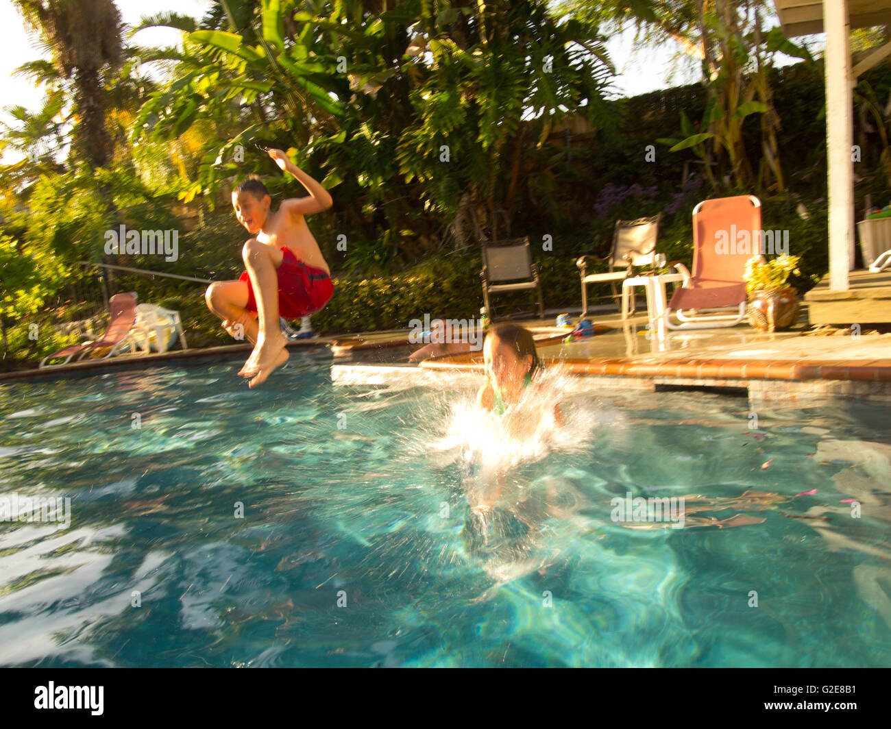 Boy Jumping in Pool Stock Photo