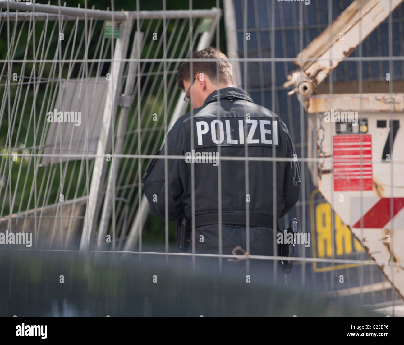 Berlin, Germany. 29th May, 2016. A policeman standing at a new building destroyed by an arson attack at Alte Jakobstrasse in Berlin, Germany, 29 May 2016. According to the police, unknown offenders lit cars on fire, destroyed windows and threw incendiary compositions on the new building. PHOTO: PAUL ZINKEN/dpa/Alamy Live News Stock Photo
