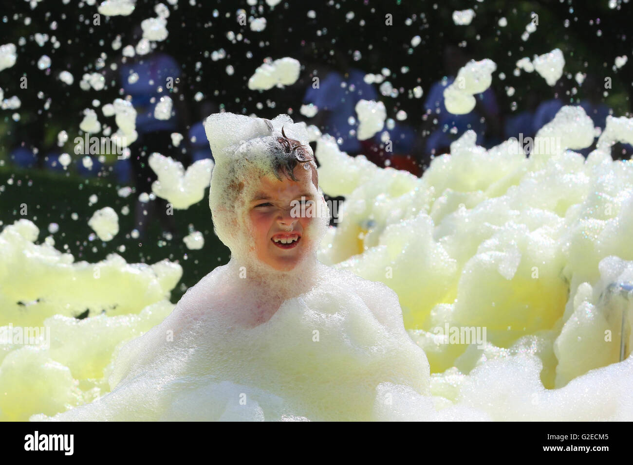 Glasgow, UK. 29th May, 2016. More than 700 people of all ages took part in a charity 'Bubble Rush' where the participants had to run through bubble stations while high powered foam cannons covered them in foam. The Fun Run was started by the TV celebrity CAROL SMILLIE who also took part in the race 'warm up' and the purpose of the event   was to raise funds for the new Prince and Princess of Wales Hospice Credit:  Findlay/Alamy Live News Stock Photo
