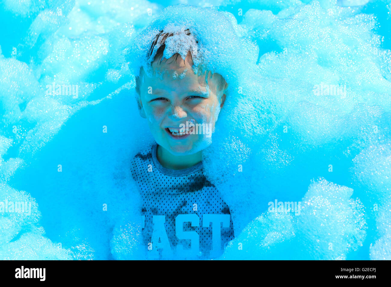 Glasgow, UK. 29th May, 2016. More than 700 people of all ages took part in a charity 'Bubble Rush' where the participants had to run through bubble stations while high powered foam cannons covered them in foam. The Fun Run was started by the TV celebrity CAROL SMILLIE who also took part in the race 'warm up' and the purpose of the event   was to raise funds for the new Prince and Princess of Wales Hospice Credit:  Findlay/Alamy Live News Stock Photo