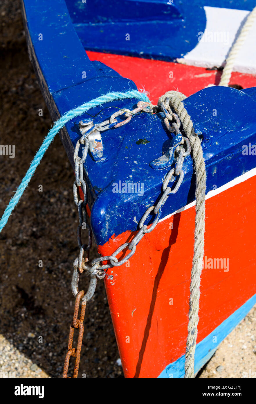 Closeup of the bow of a small boat painted in vivid red and blue with