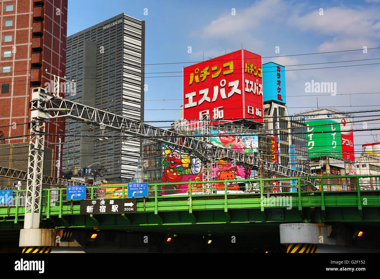 Buildings and advertising signs and railway line in Shinjuku in Tokyo, Japan Stock Photo