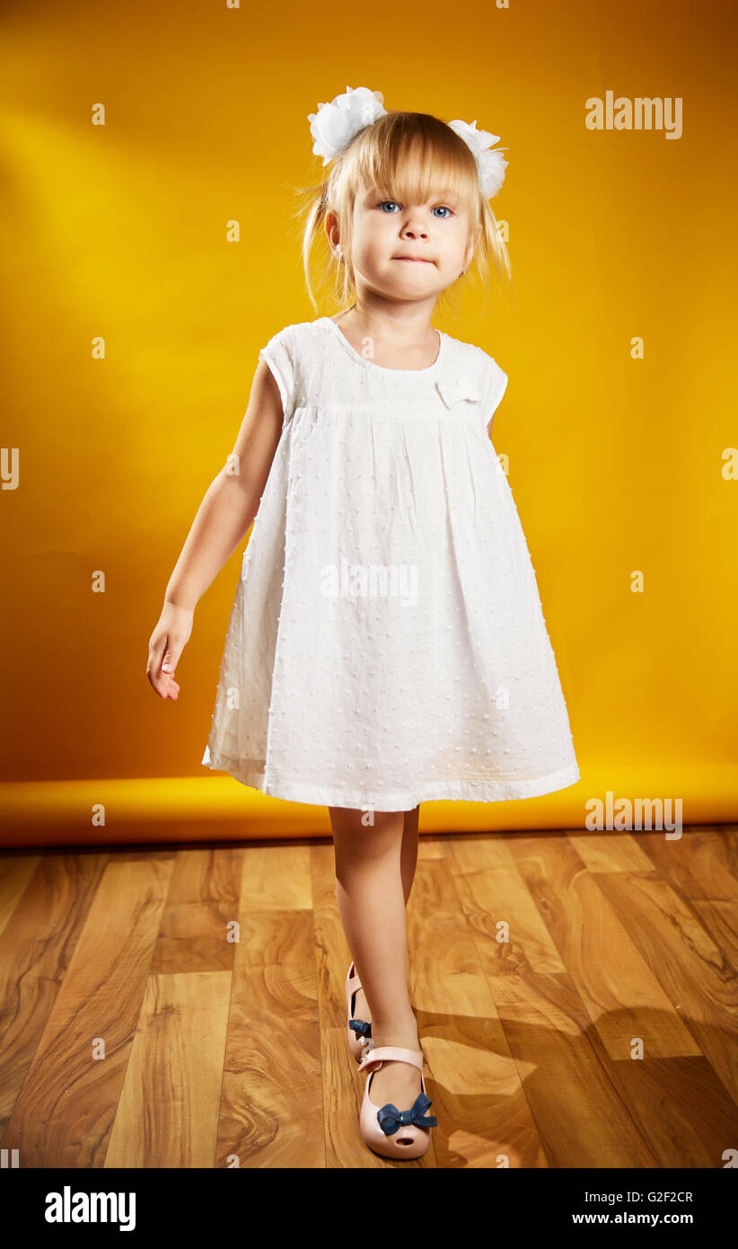 little girl with bows and fooling around in a white dress Stock Photo ...