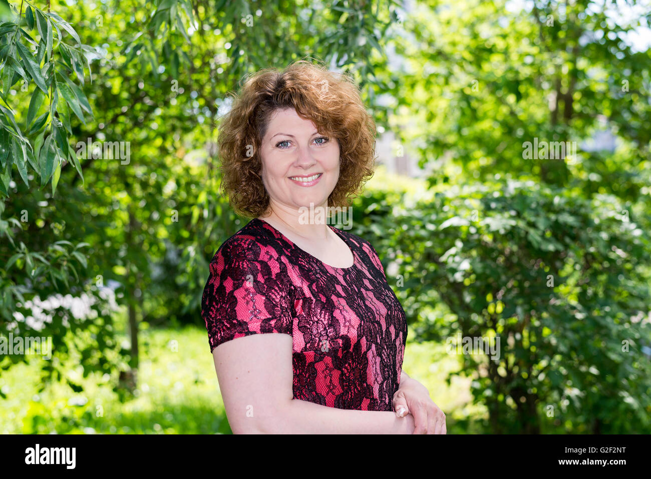 Portrait curly woman in summer park Stock Photo - Alamy