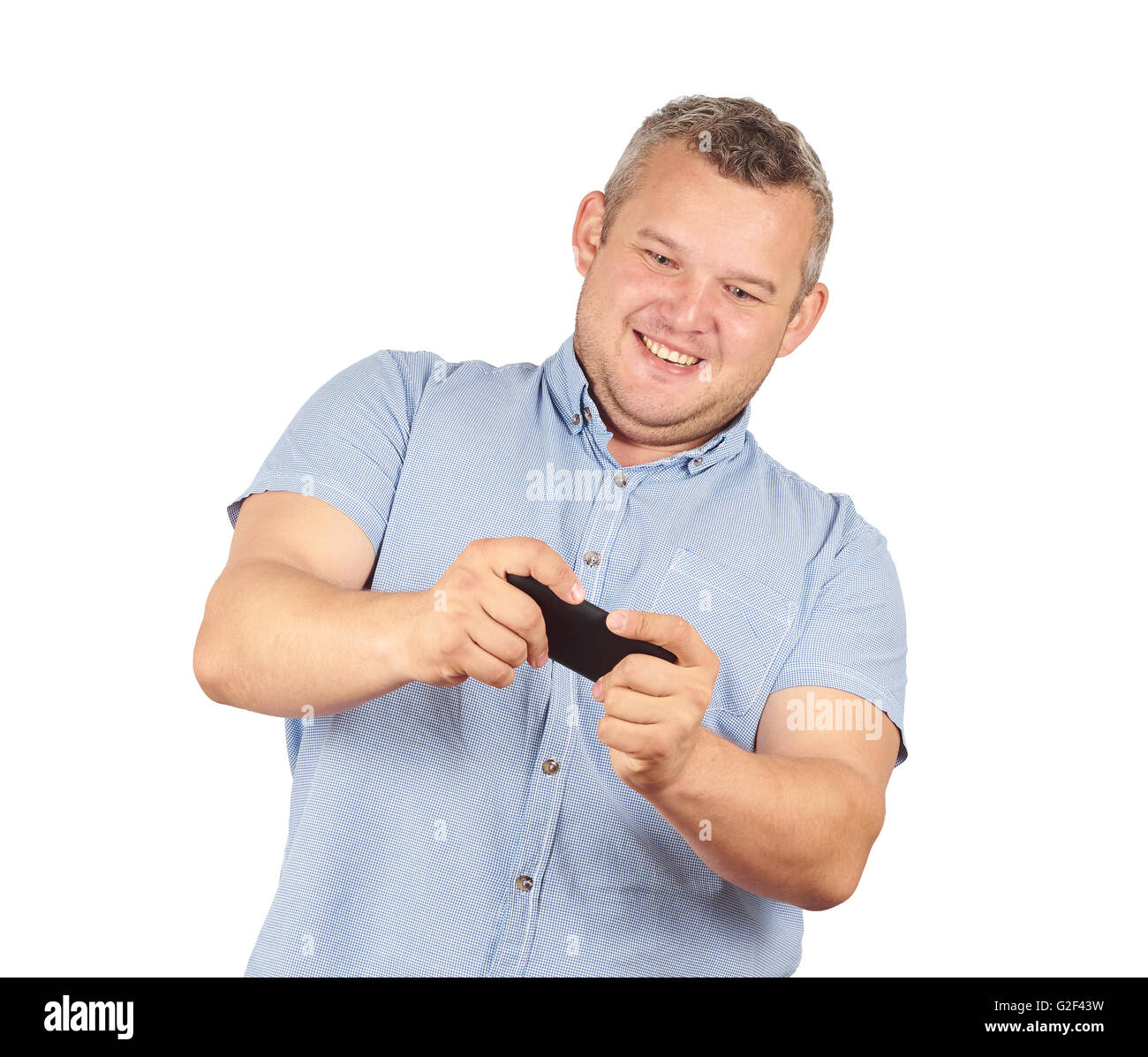 fat man looks at the phone. Playing on a smartphone. Bad news. Emotions.  Isolated on white background. Stock Photo