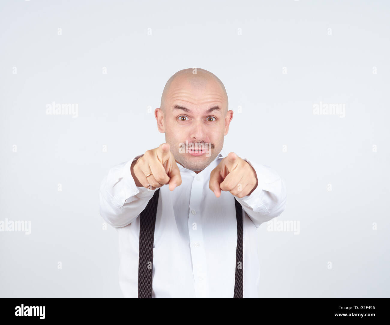 Haughty bald man with a mustache. It points the finger at the camera. Stock Photo