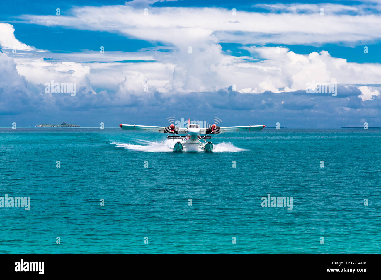 Twin otter red and white seaplane landing at Maldives Stock Photo