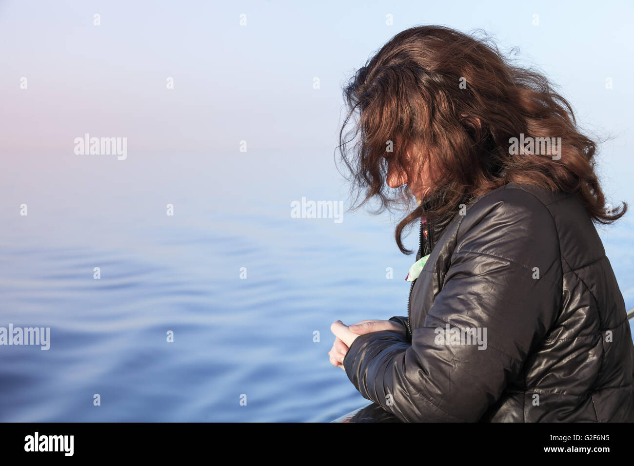 Young Caucasian woman stands on the walking deck of cruise ship, close-up profile portrait Stock Photo