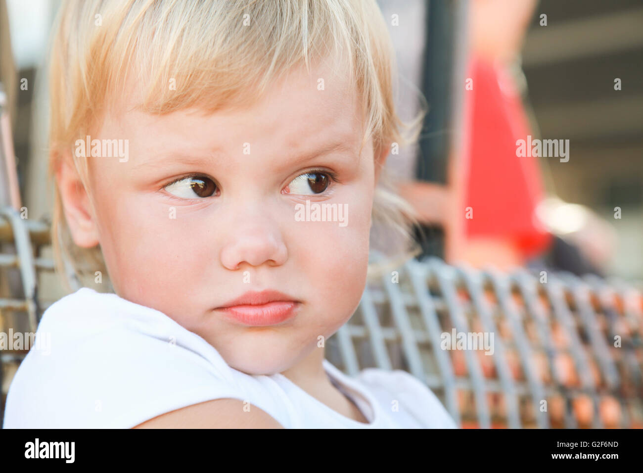 Outdoor closeup portrait of displeased cute Caucasian blond baby girl Stock Photo